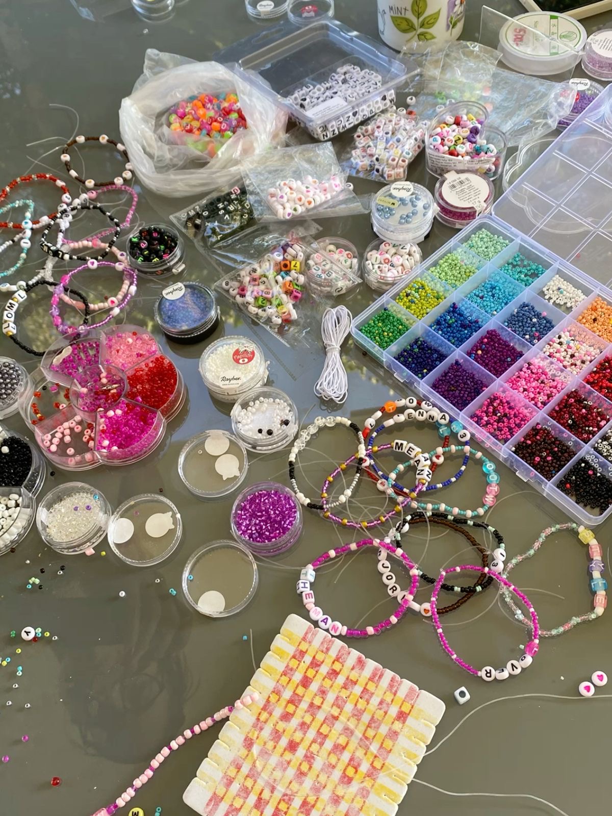 Bead-making workshop tools, seed beads and friendship bracelets in progress