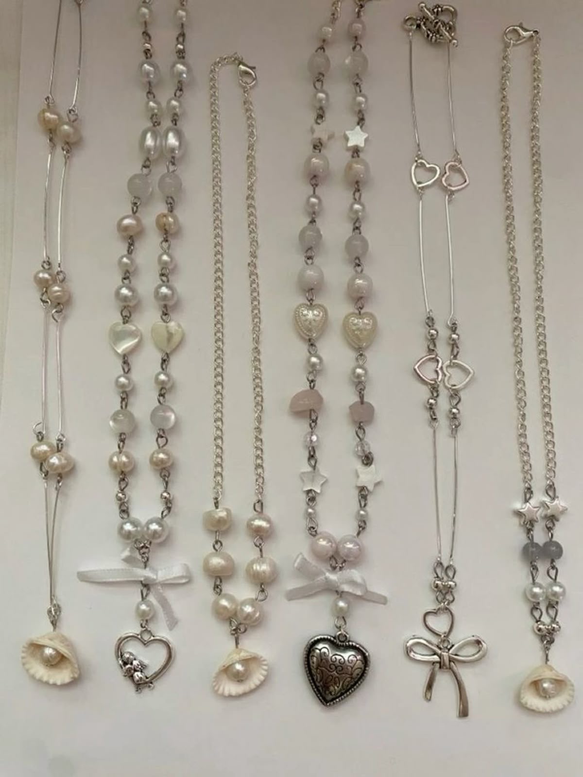 Handcrafted silver chain and pearl necklaces with heart and shell charms